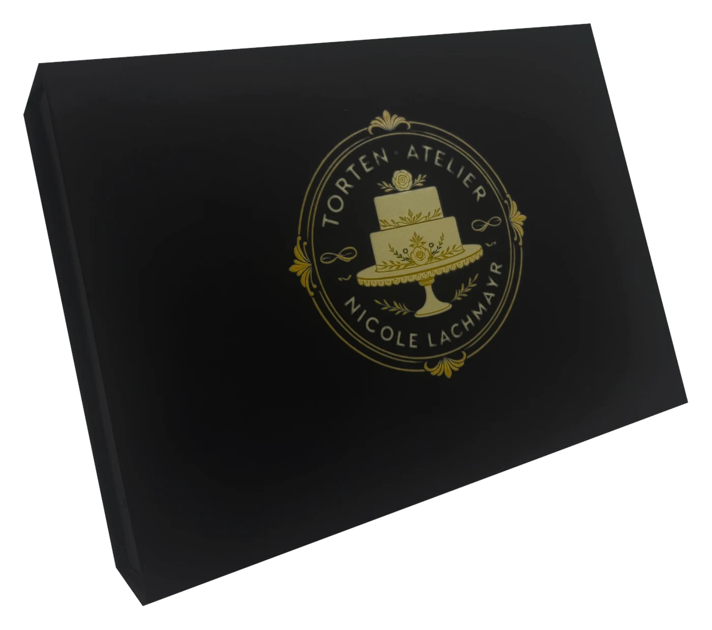 Geschenkbox mit grünem Seidenband und Logo-Anhänger des Torten Ateliers