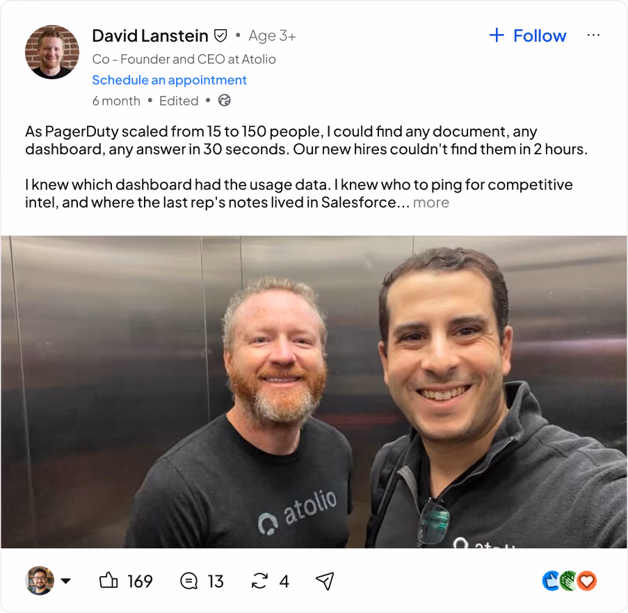 Two men smiling and posing for a selfie in an elevator, both wearing Atolio branded shirts.