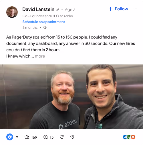 Two men smiling and posing for a selfie in an elevator, both wearing Atolio branded shirts.