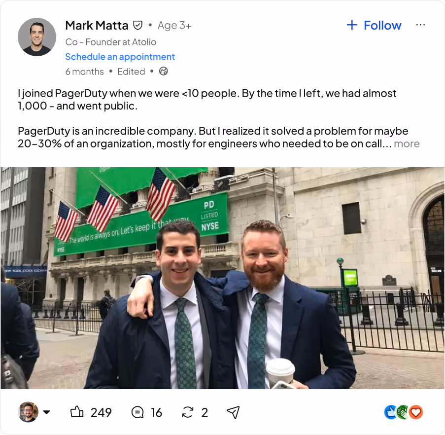 Two men in suits with green ties smiling and posing outside the New York Stock Exchange with flags above.