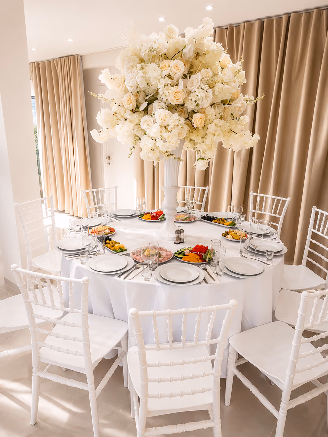 Feestzaal met ronde tafels en luxe bloemendecoratie