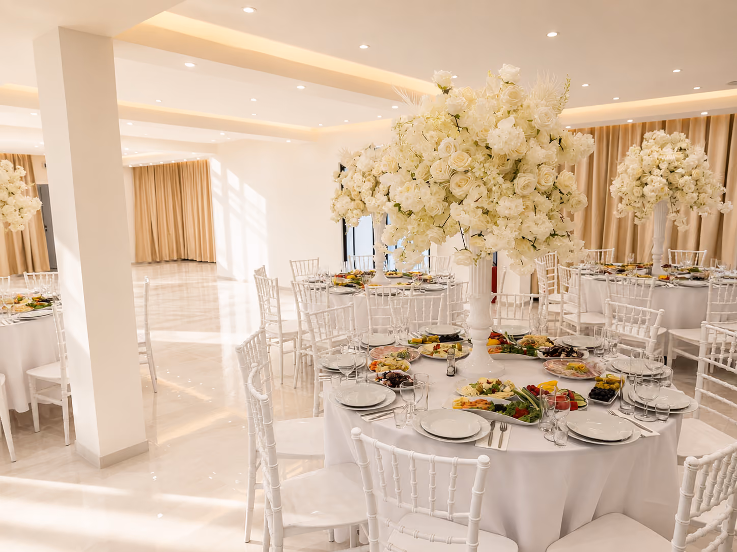 Sfeervolle zaal met gedekte tafels en witte bloemendecoratie