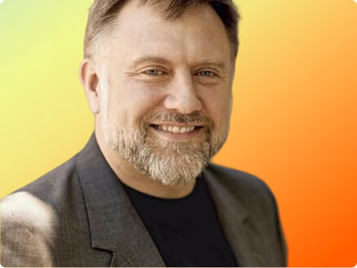 Nicholas Holland headshot on orange gradient background