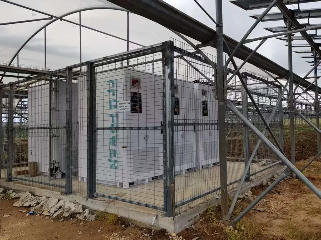 FFD POWER Batterieschränke in einem umzäunten Sicherheitsbereich unter einer Gewächshaus-Solaranlage in Israel