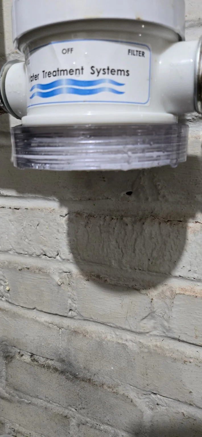 Failed water-treatment filter housing involved in a basement leak at an Asheville-area home.