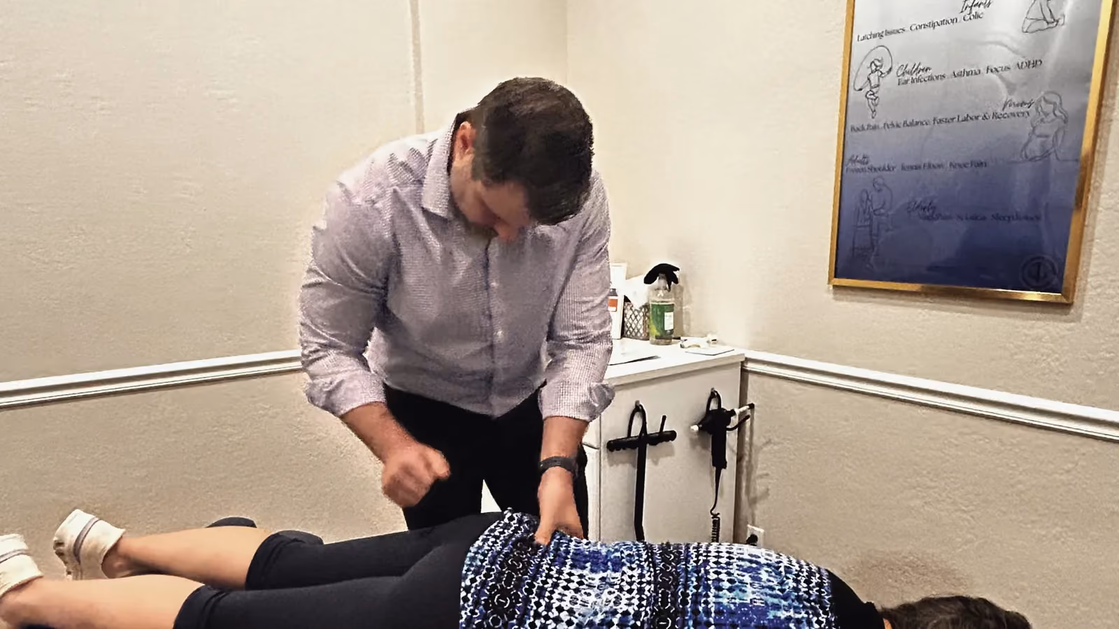 Chiropractor assessing a patient’s spine