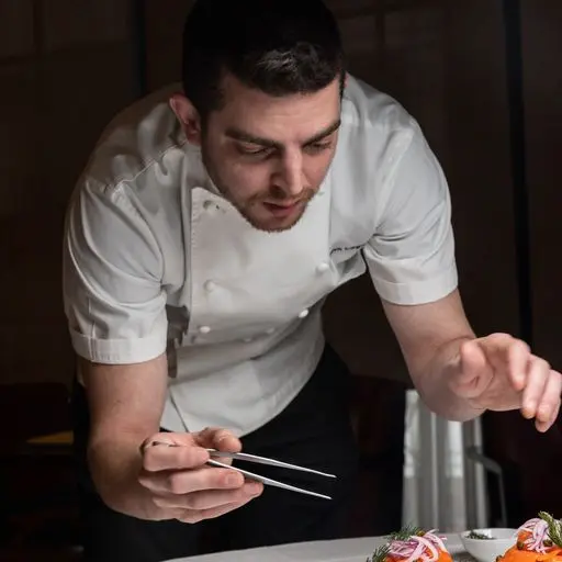 Executive Chef Jack Logue carefully plating a seasonal tasting menu course at Amphora, a fine dining restaurant in Manhattan’s Flatiron District.