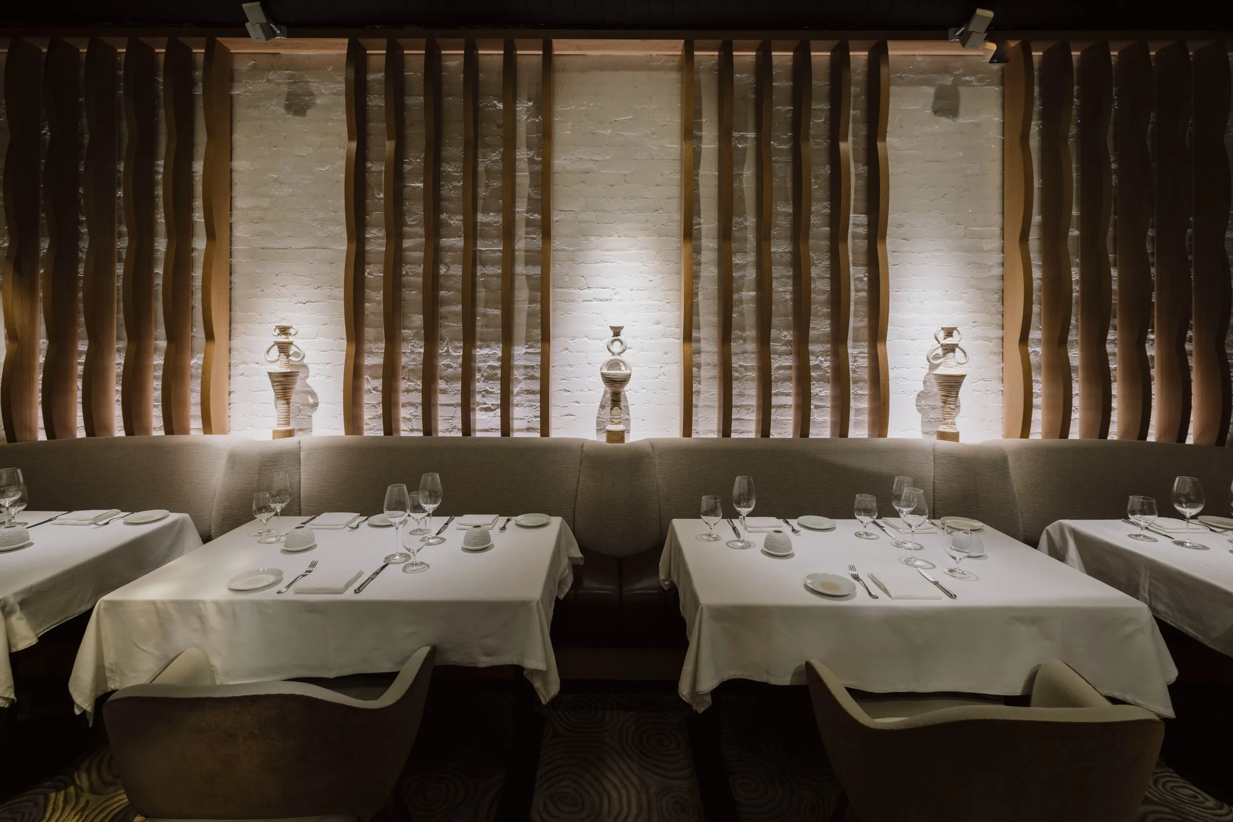 Elegant dining room at Amphora featuring handcrafted amphora sculptures, sculptural wood walls, and intimate fine dining seating in Manhattan’s Flatiron District.