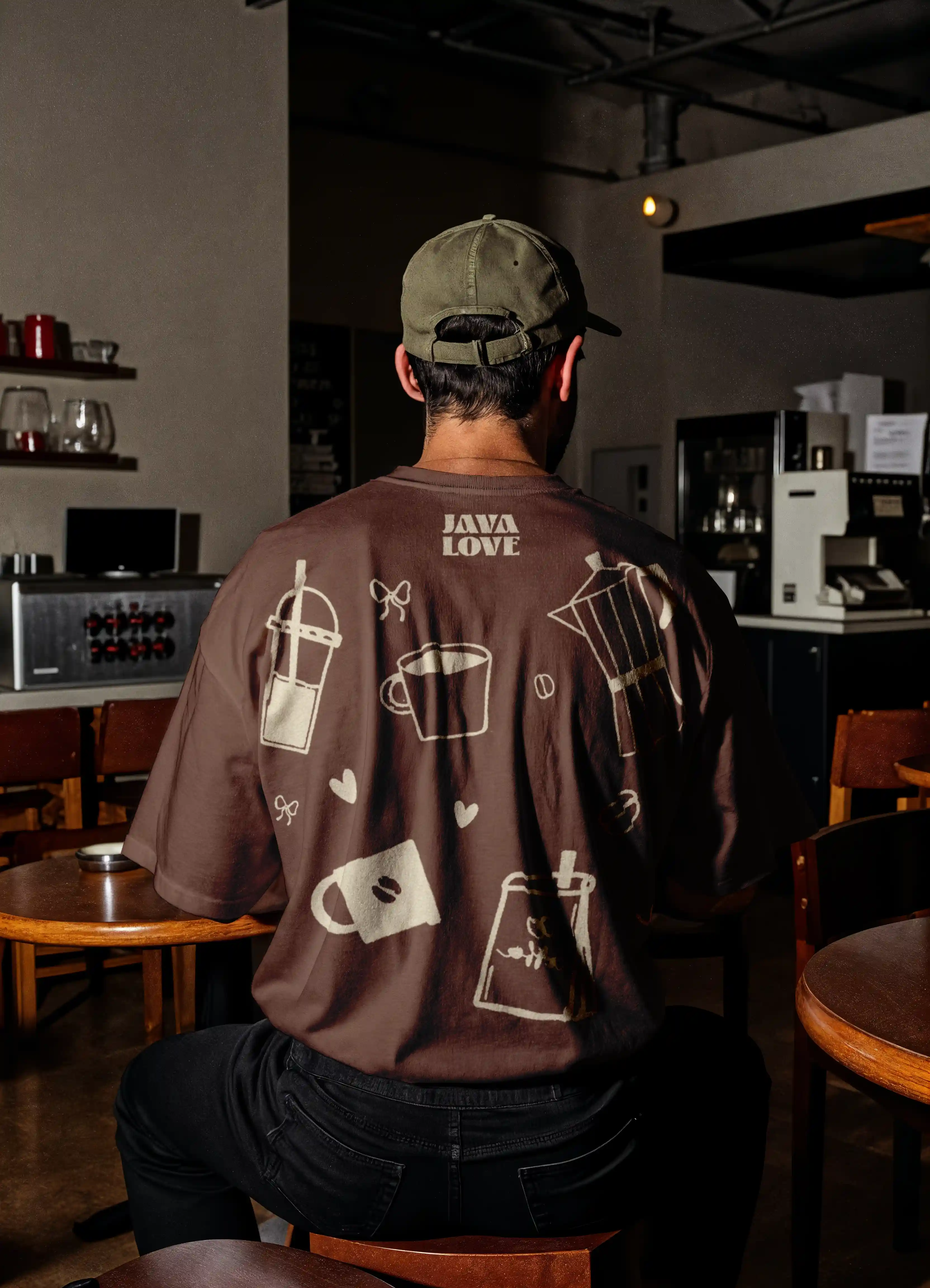 Man wearing brown T-shirt with coffee-themed illustrations and the text 'JAVA LOVE' on the back.