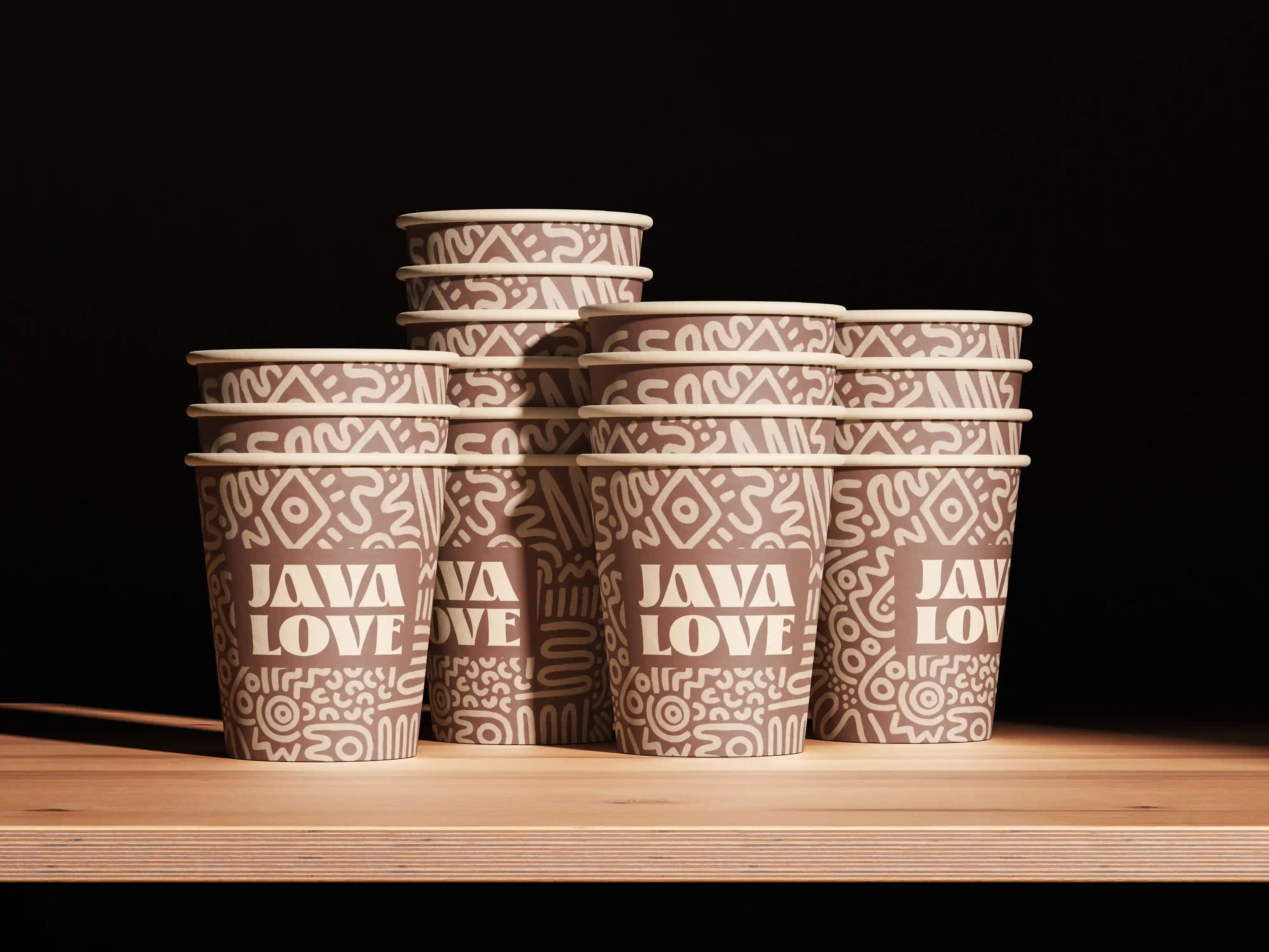 Stacked paper coffee cups with 'JAVA LOVE' text and abstract patterns on a wooden surface.