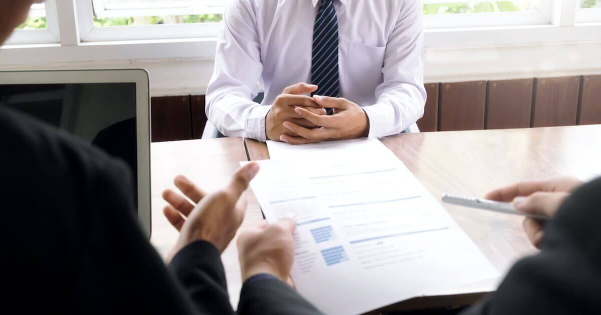 Two HR managers conduct a meeting with a male employee