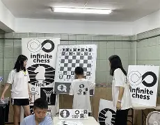 Students and instructors standing near a large magnetic demonstration board during an Infinite Chess session
