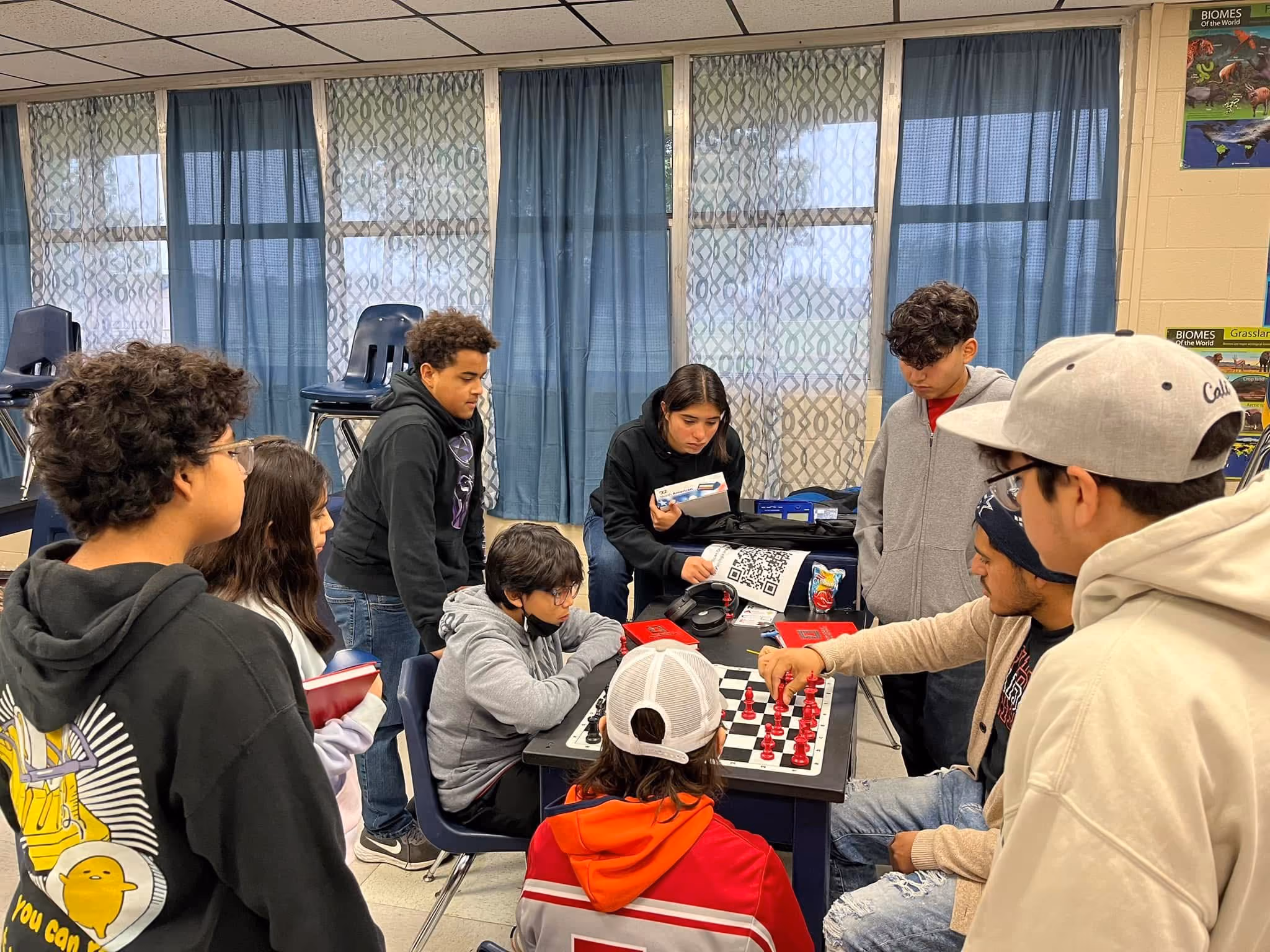 Students gathered around a board during an after-school coaching session hosted by the UWCF.  Shared by RGV Chess and Learning Center.