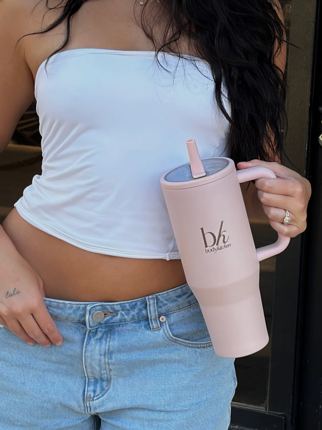 BodyKitchen 40oz water bottle in hand outside the studio