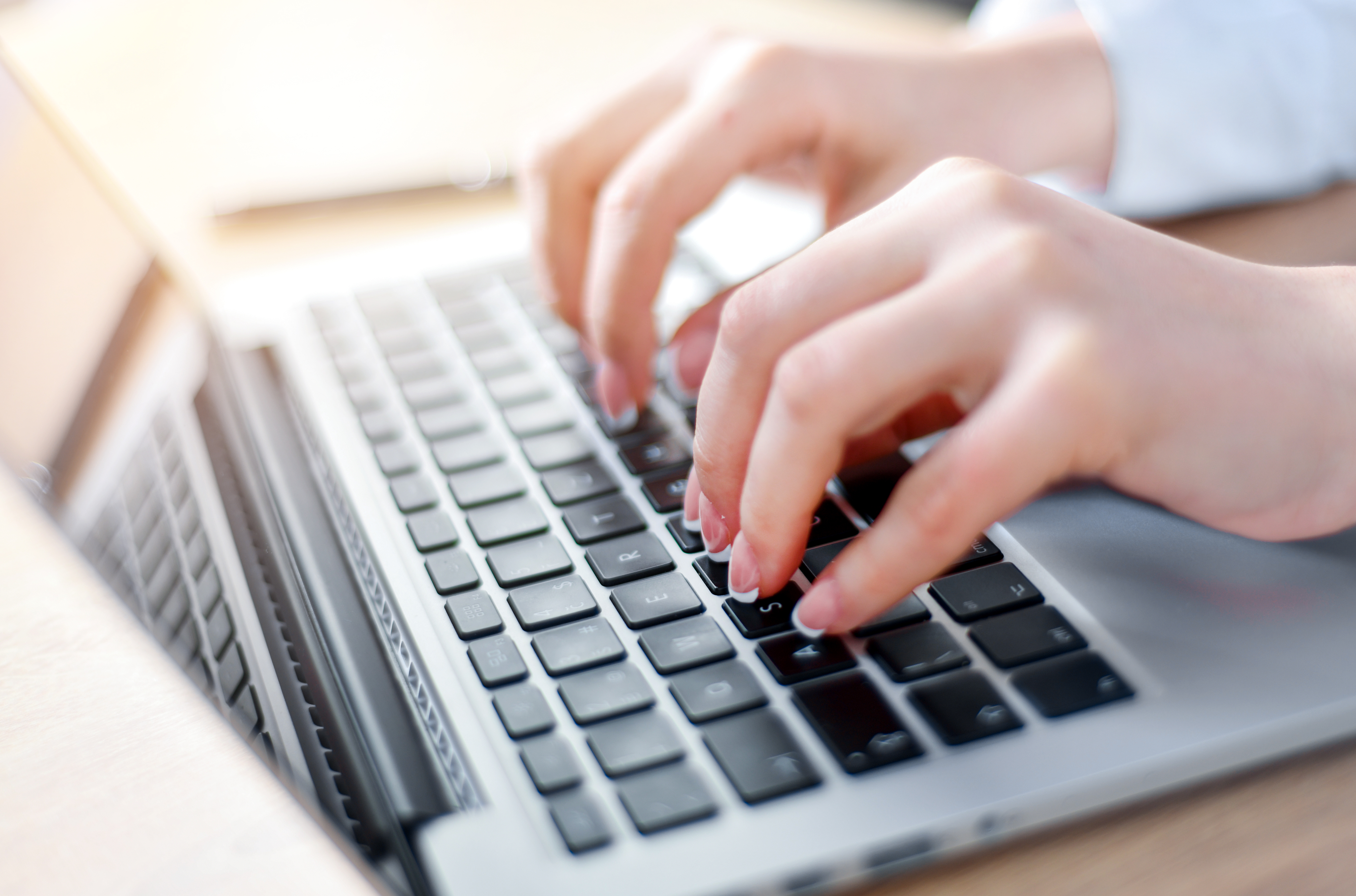 Typing a club photo day booking on a laptop