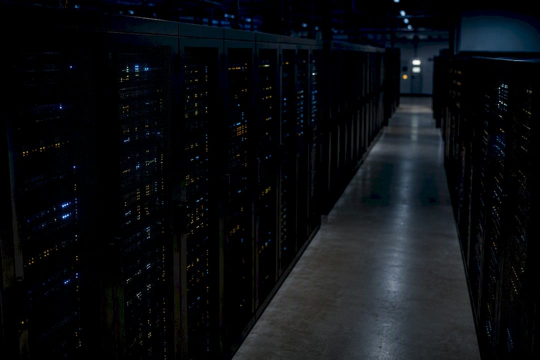 Idle servers glowing in darkened rack aisle