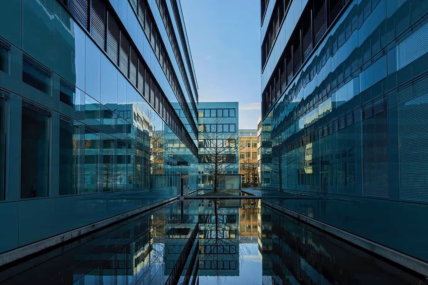 Edificios de oficinas modernos de vidrio a ambos lados de un estanque reflectante