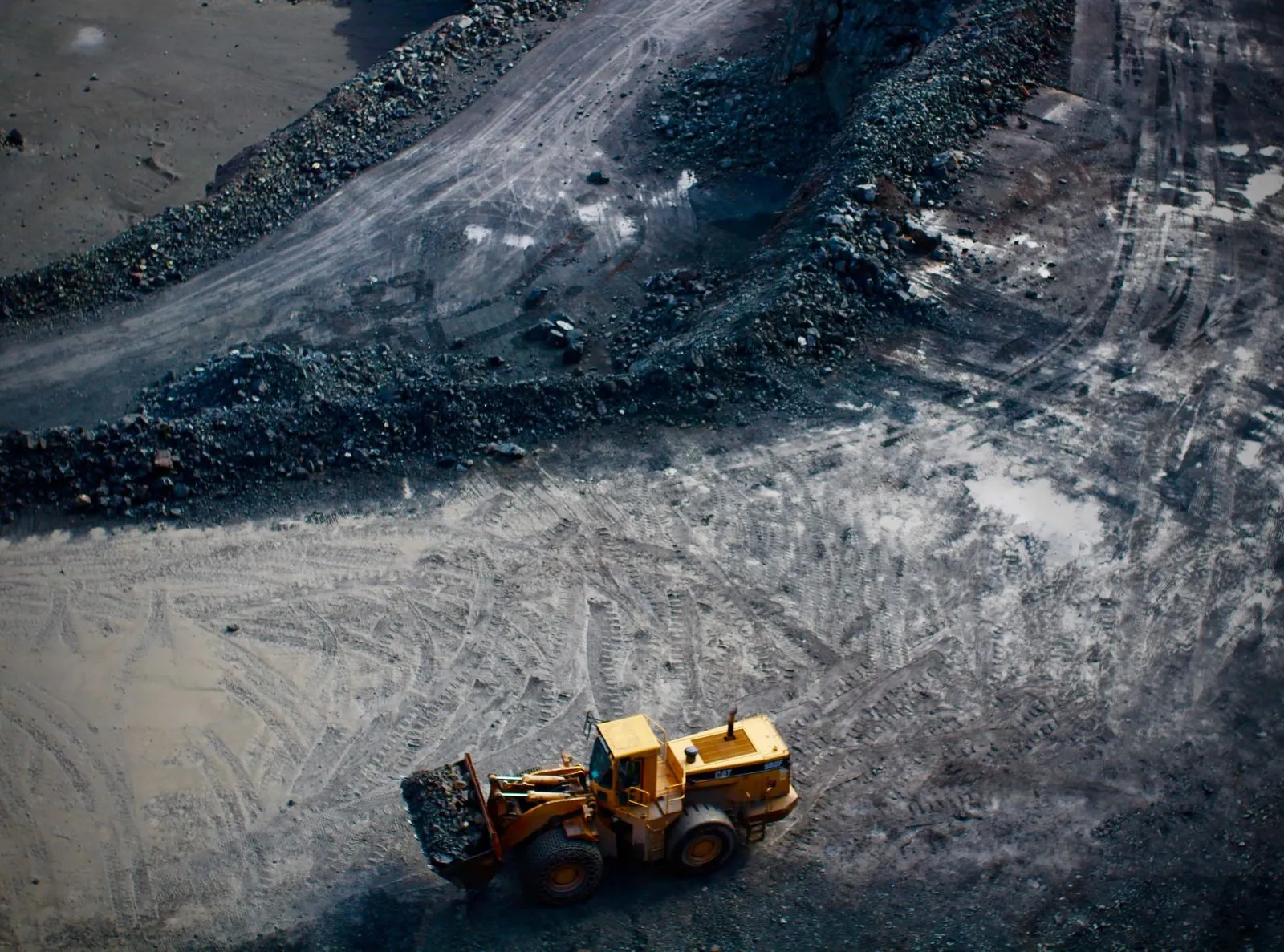 Vista aérea de un cargador de ruedas trabajando sobre una pila de roca chancada