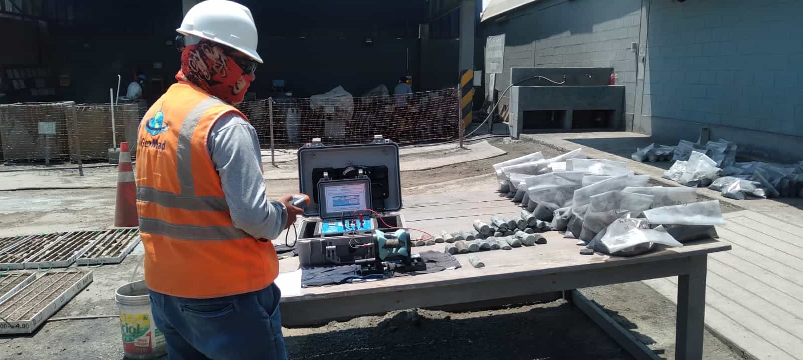 Trabajador que examina muestras de roca con un equipo portátil de análisis