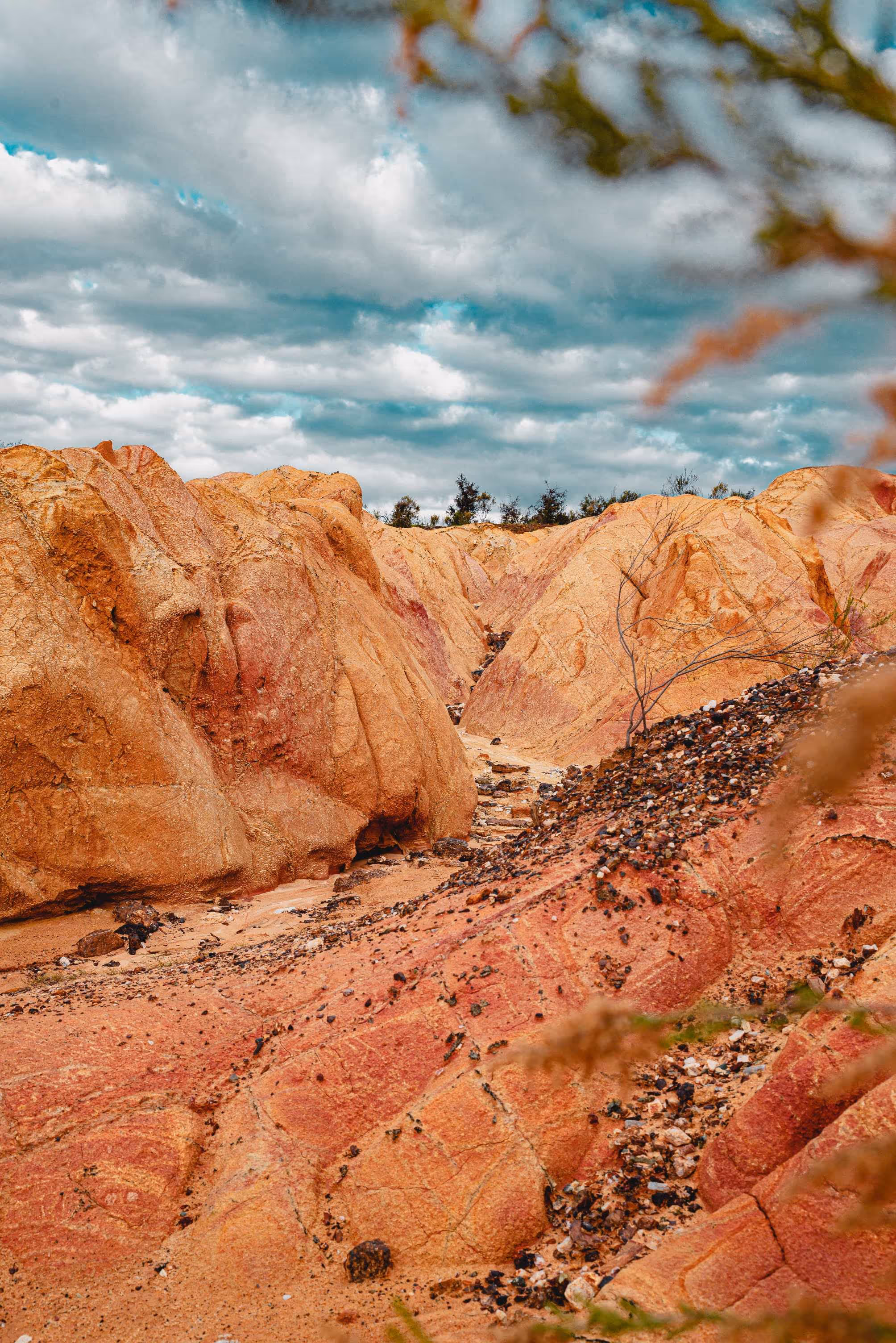 Eroded orange and red rock formations under a cloudy sky