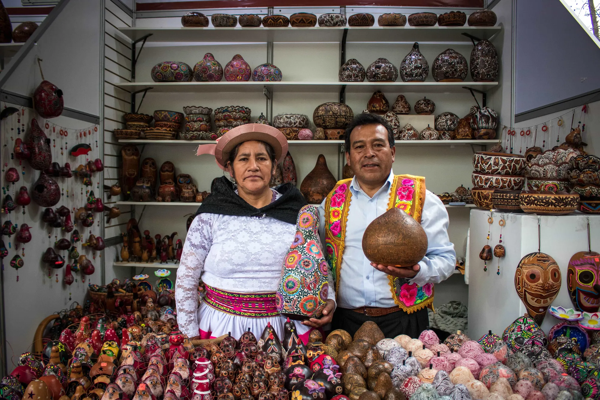 Dos comerciantes de pie entre productos artesanales en su tienda