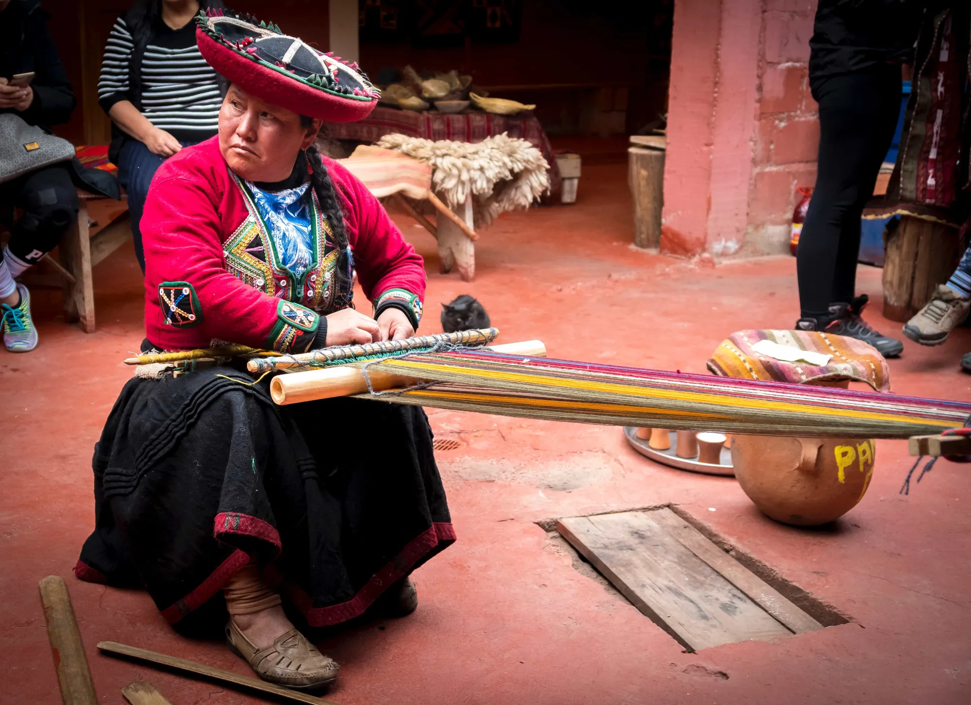 Tejedora trabajando en un telar de cintura en un patio