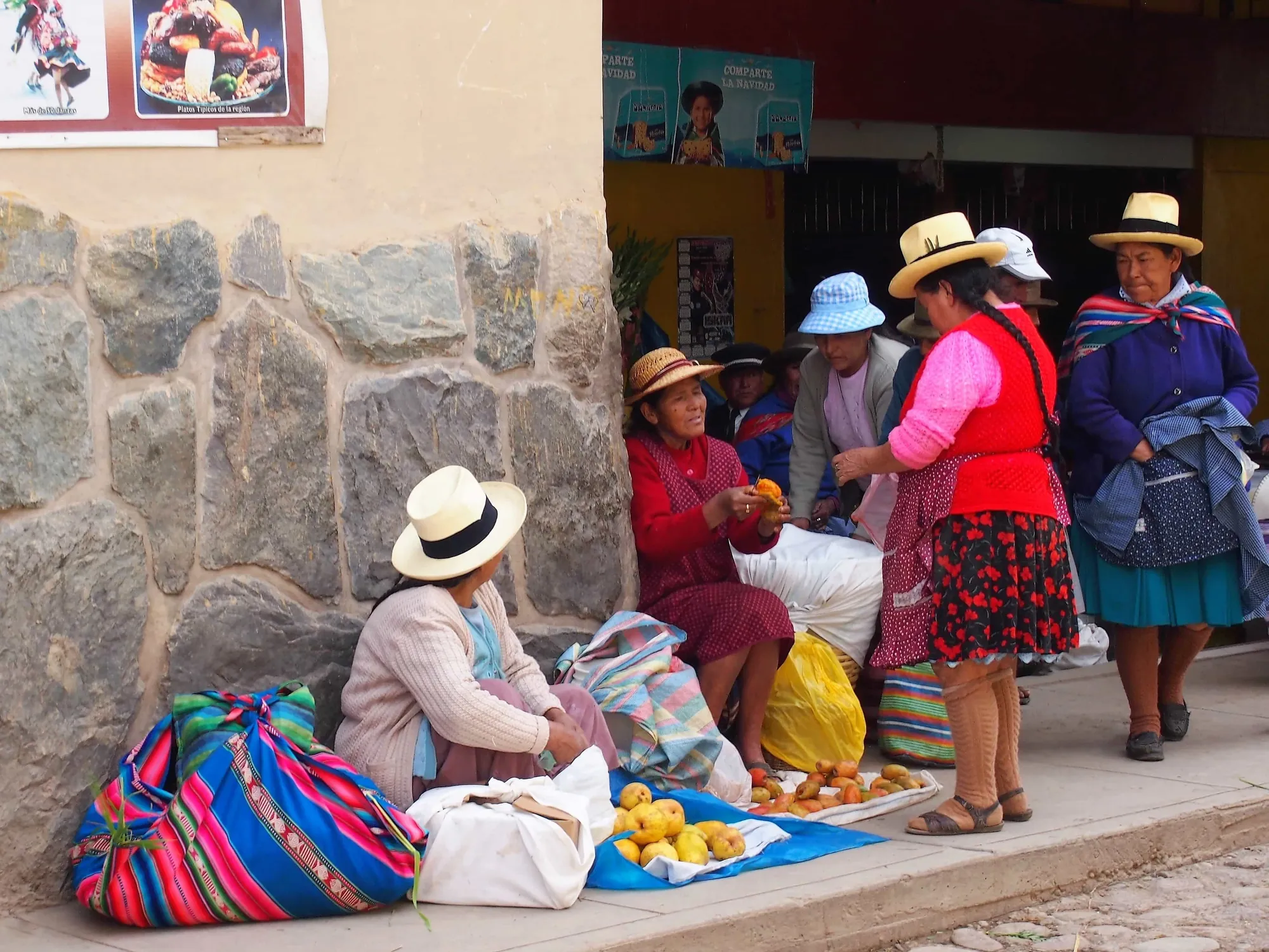 Seis mujeres vendiendo naranjas en un mercado callejero en el Perú