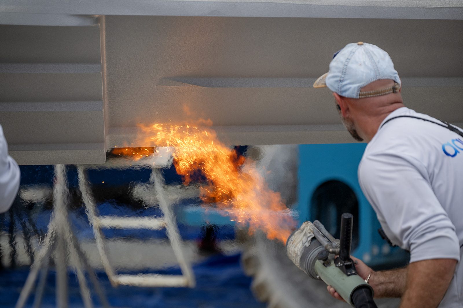 A licensed dealer heat-embedding Aquaphobix™ into a prepared hull with a torch