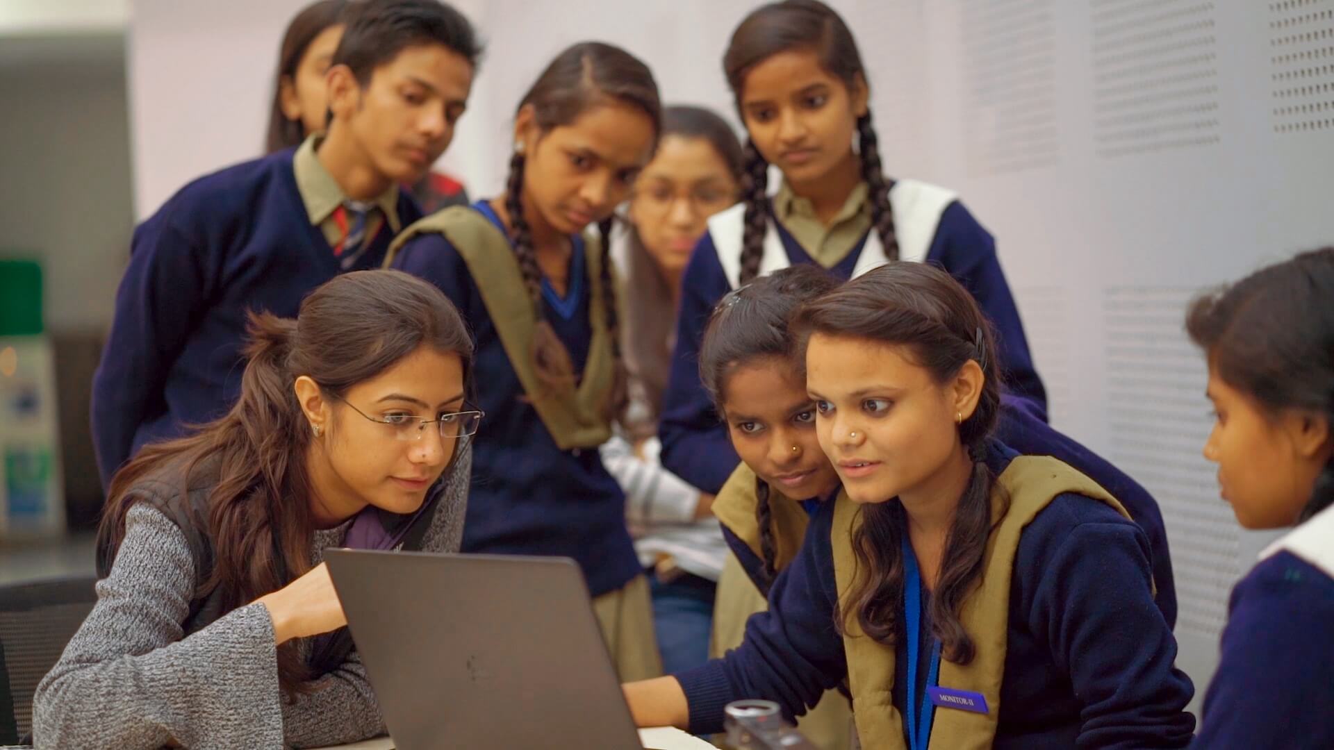 Students working on laptops together, India