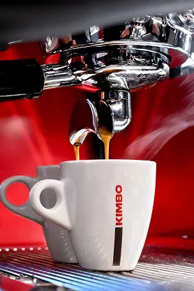 Espresso aparat sipa kafu u Kimbo šoljicu, krupni kadar pripreme espresa.