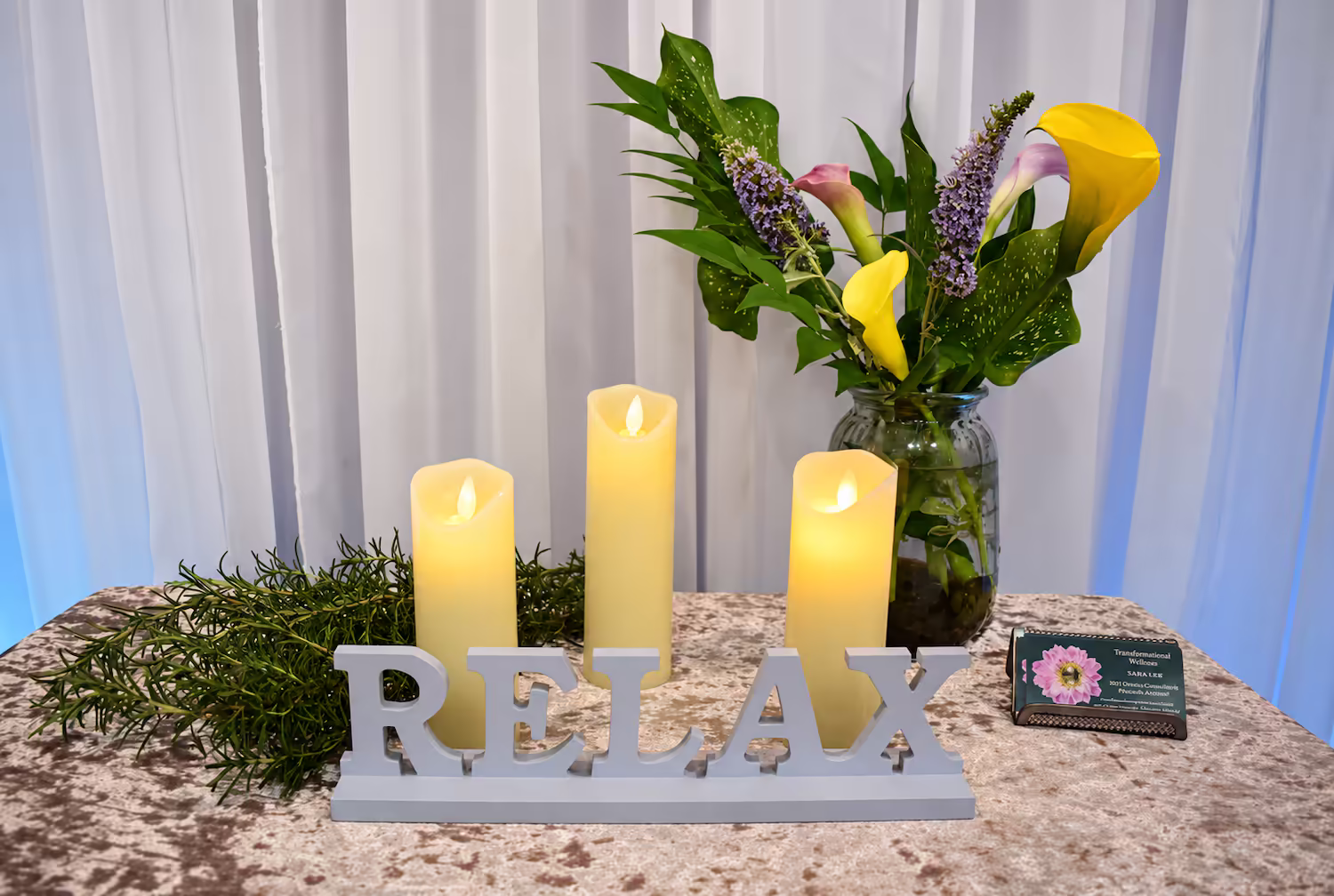 Candles and fresh flowers beside a Relax sign