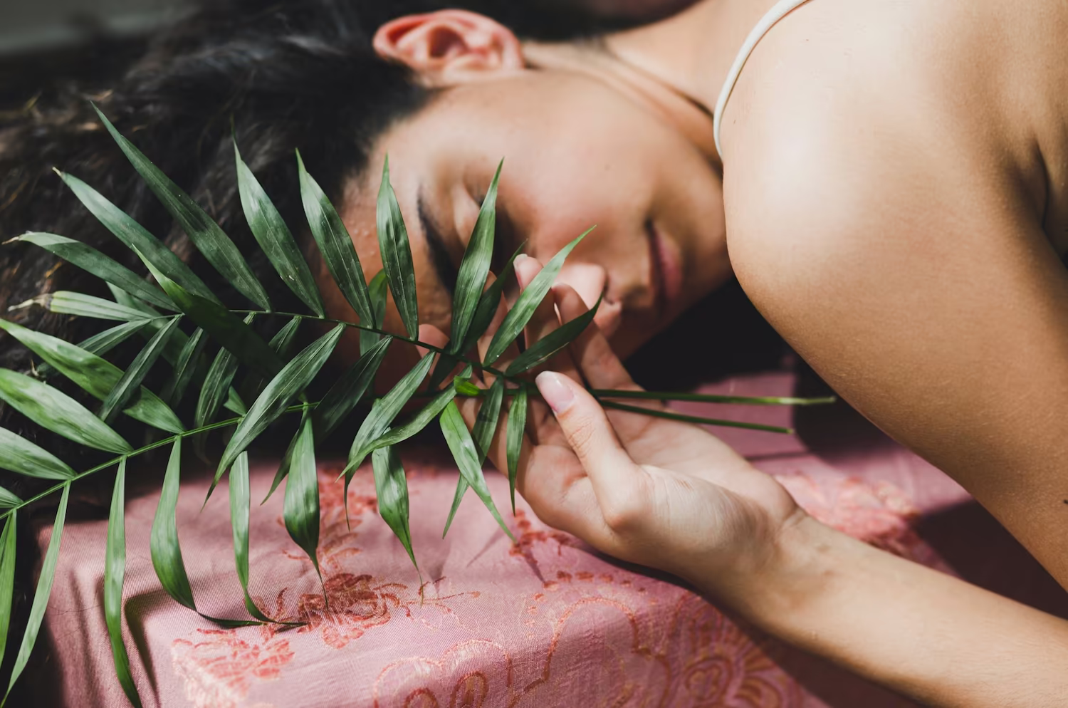 Woman relaxing with her eyes closed among green plants