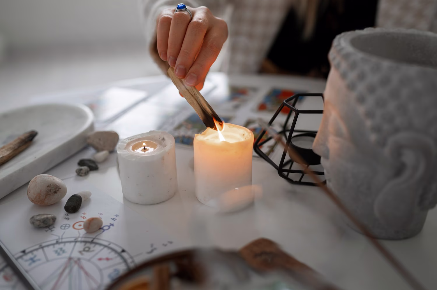 Lighting a candle beside crystals and a Buddha figure