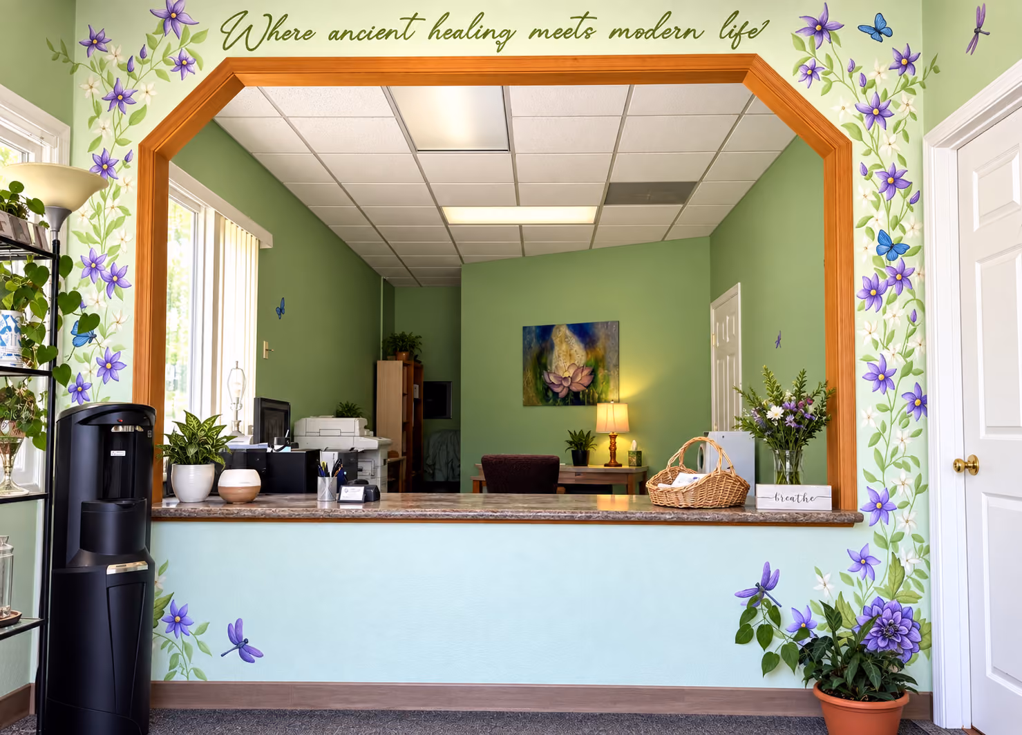 Reception desk with the mural Where ancient healing meets modern life