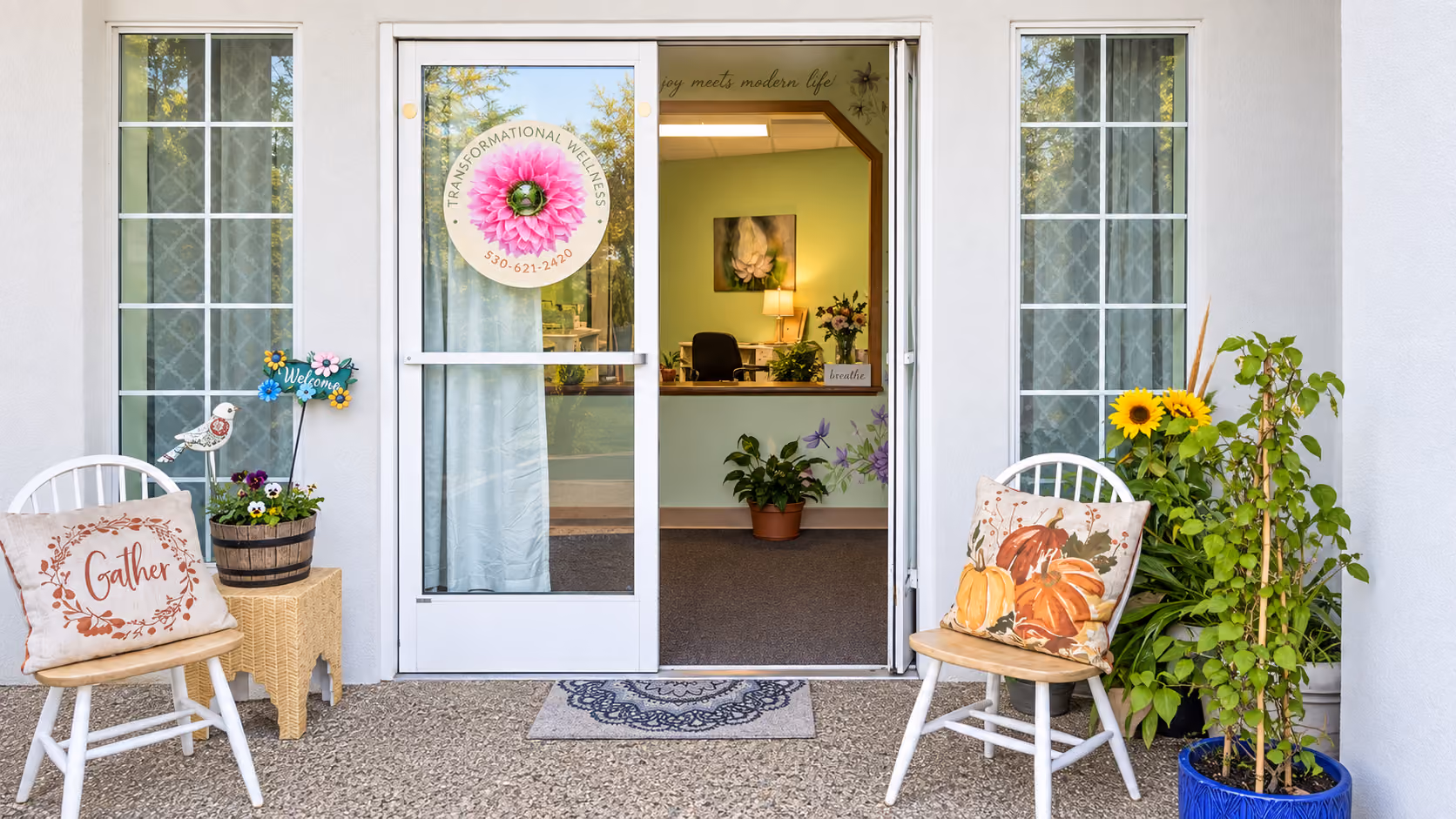 Front entrance of Transformational Wellness with flowers and a welcome wreath