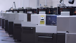 Row of industrial printing machines in a factory setting.