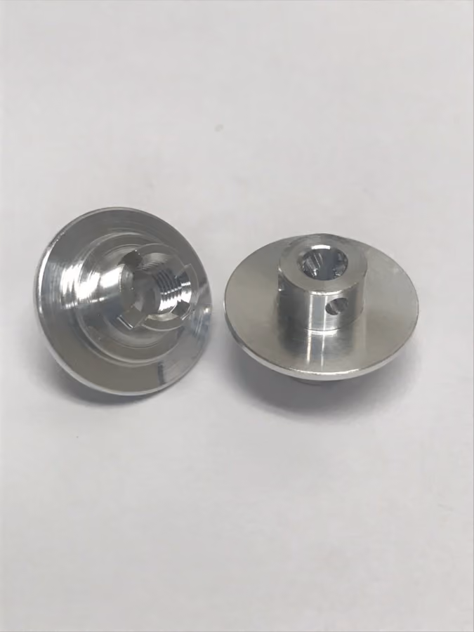 Two silver metal threaded fasteners with flanged heads on a white surface.