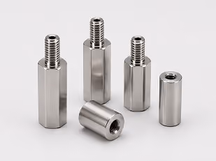Five metal standoffs with threaded ends arranged on a light surface.