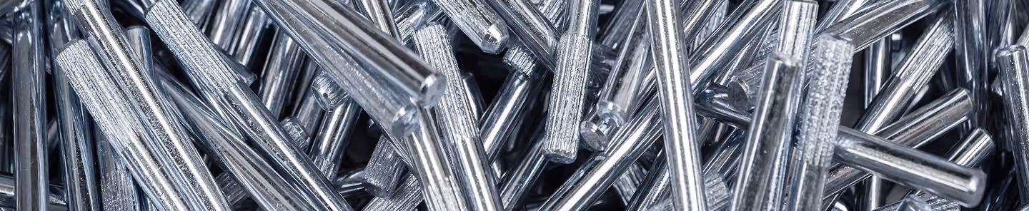 Close-up of shiny silver metal cylindrical rods tightly packed together.