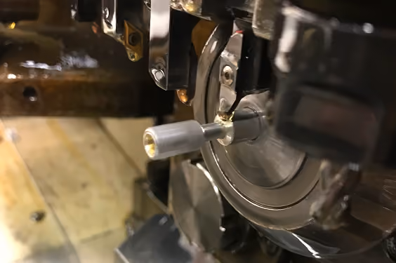 Close-up of a metal part being machined on a precision lathe or milling machine.