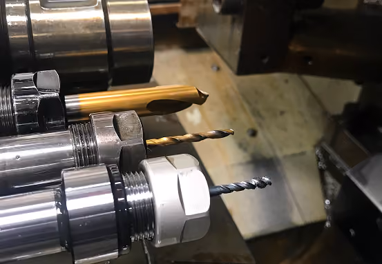Close-up of metal drill bits mounted on a machine tool in a workshop.