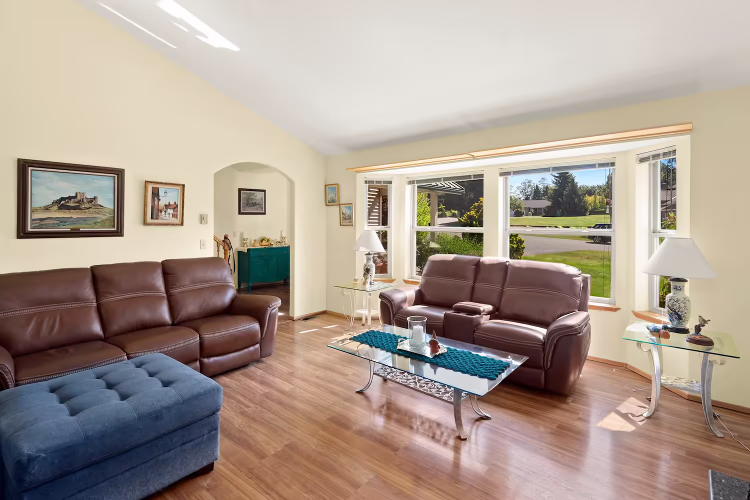 Bright living room with clean hardwood floors and leather sofas
