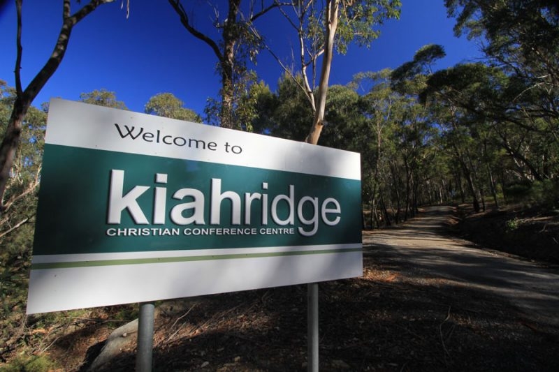 A roadside sign reading Welcome to Kiah Ridge Christian Conference Centre, set among bushland.