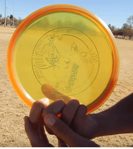 A modified power grip on a yellow disc, the fingers only partly curled under the rim.