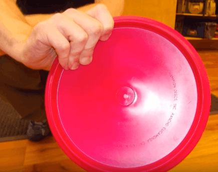 A fan grip on a pink disc seen from behind, showing the fingers fanned beneath the rim.