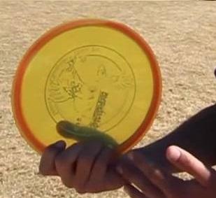 Close-up of a modified power grip on a yellow disc, showing the thumb resting on top.