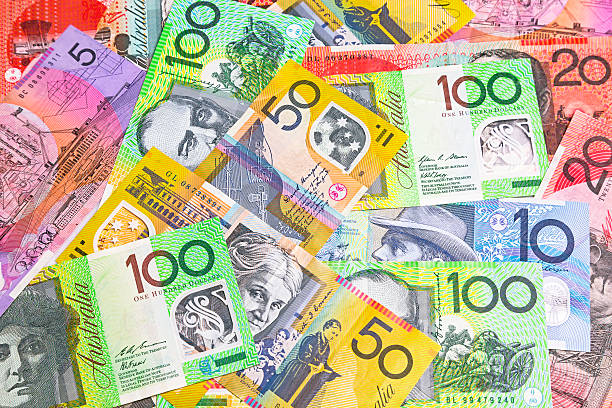 Australian banknotes of mixed denominations scattered across a surface.