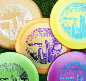 A pile of brightly coloured discs stamped with a GCC 17 city skyline tournament design.