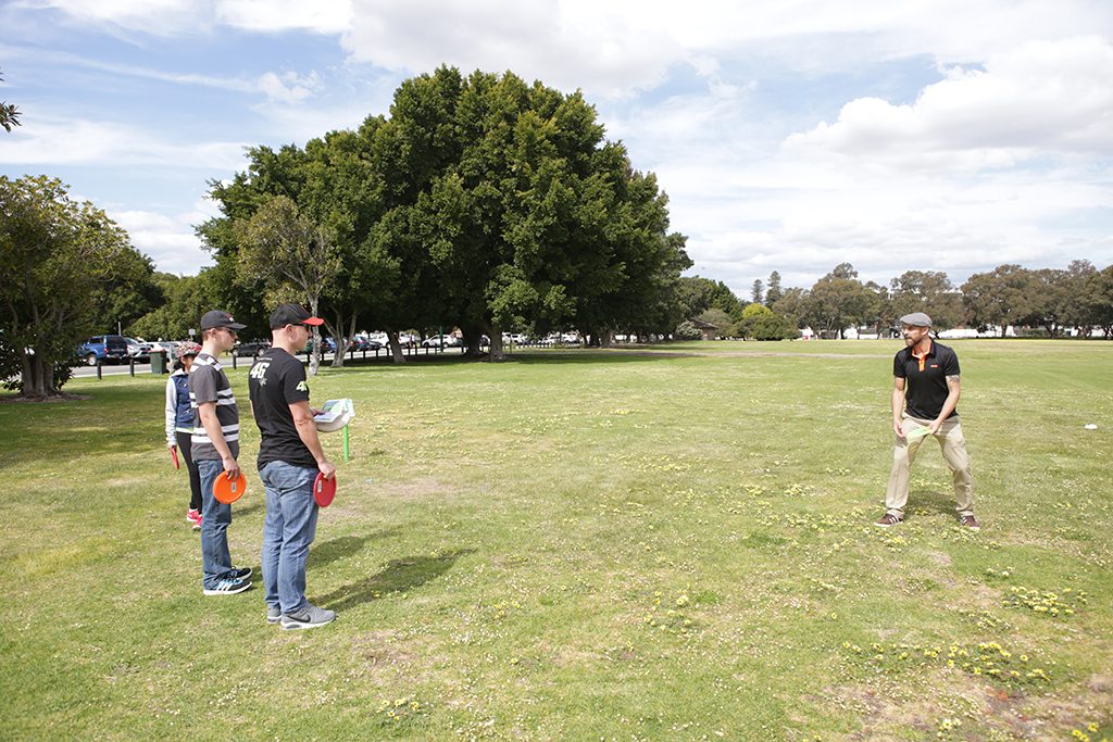 Players throwing across a wide open park at a come-and-try day.