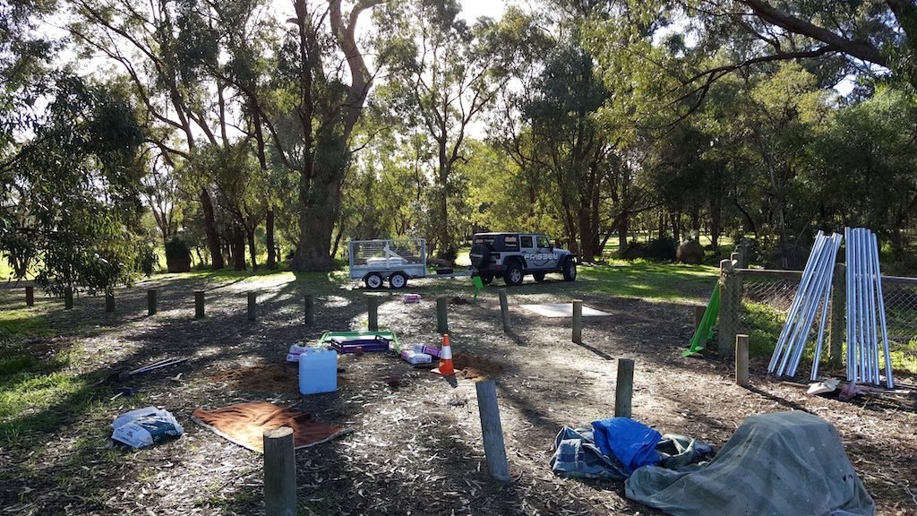 A course installation under way in bushland, with vehicles, baskets and materials laid out among the trees.